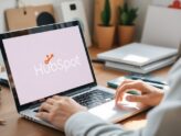 Person using laptop with HubSpot logo in workspace.